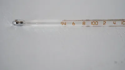 Detailed image of a glass thermometer displaying temperature in degrees.