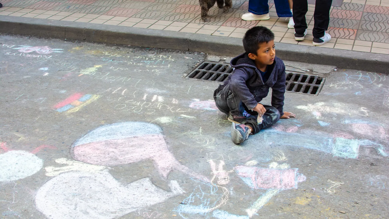 Colourful chalk drawings on a public pavement, showing community participation and creative expression.