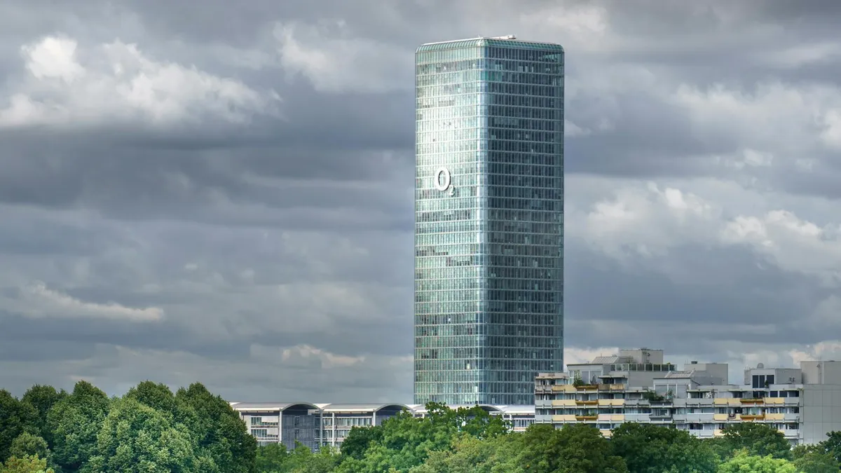 The Highlight Tower in Munich rises against a backdrop of dramatic clouds, capturing urban architecture.