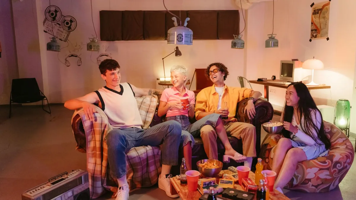 Four friends enjoying a fun night indoors with snacks and laughter.