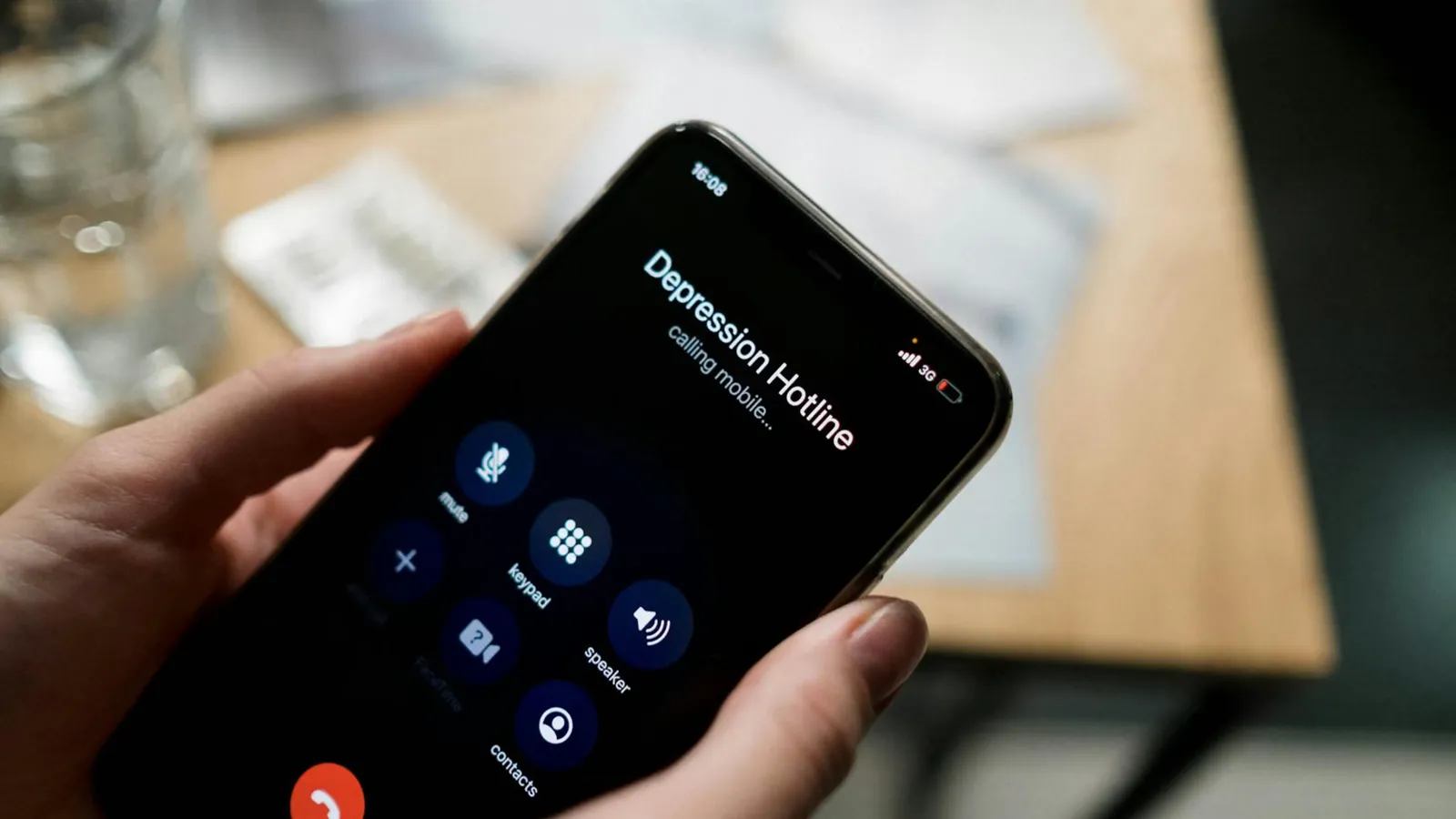 Close-up of a person holding a smartphone, calling a depression hotline.