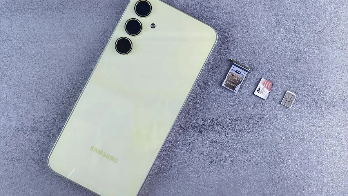 An overhead shot of a light-colored smartphone next to a SIM card tray and two SIM cards.