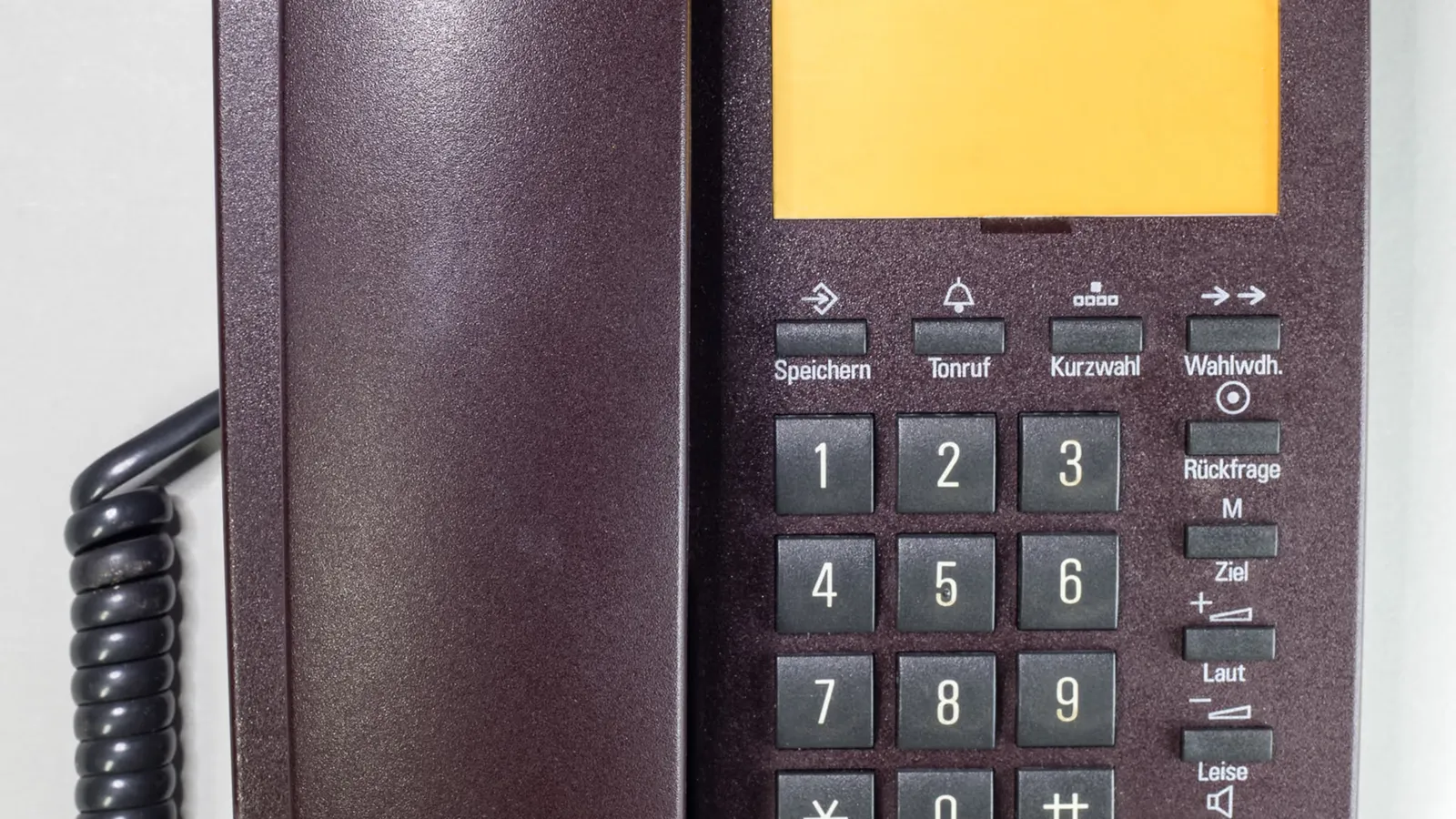 Close-up of a traditional landline telephone handset on a desk