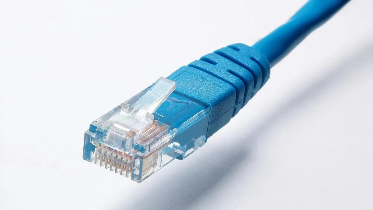High-quality image of a blue Ethernet cable plug on a white background, ideal for tech themes.