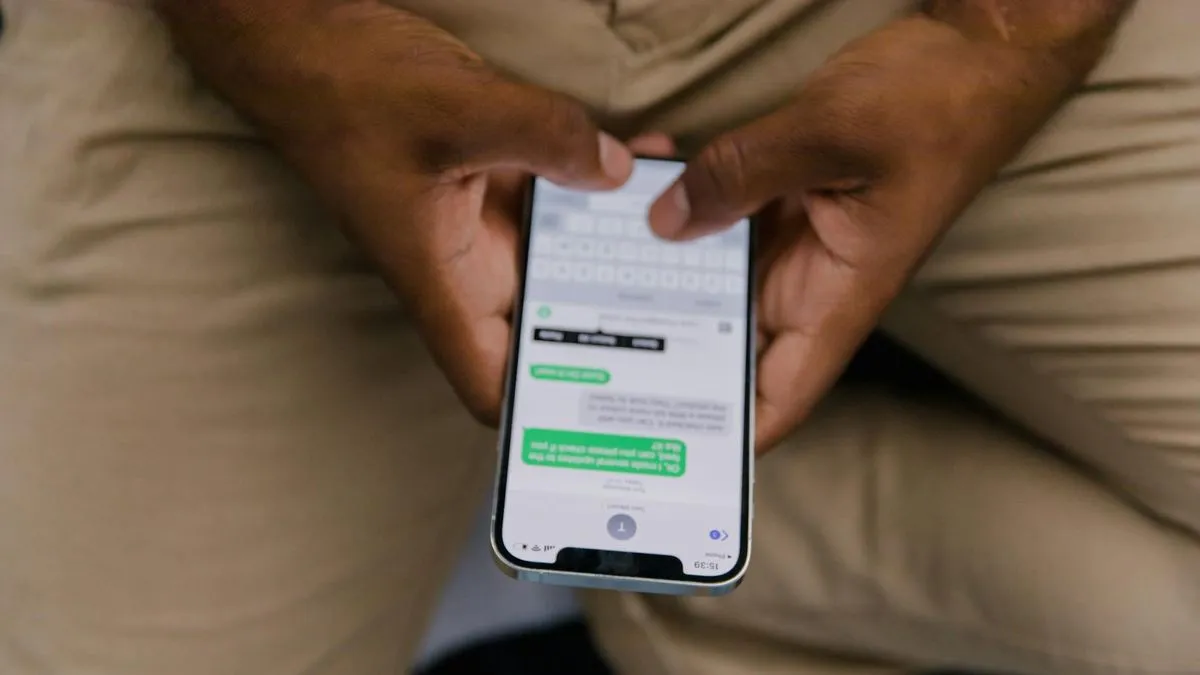 A person's hands holding a smartphone, actively typing a message on the screen.