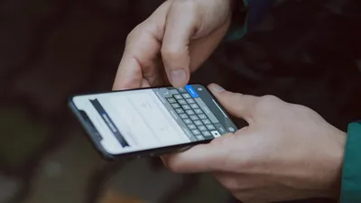 Close-up of person texting on a smartphone. Outdoor setting with wireless connectivity.