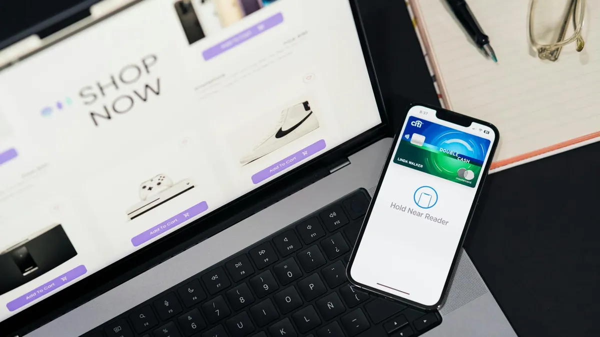 Laptop showing e-commerce site with a smartphone for mobile payment. Ideal for tech and shopping themes.