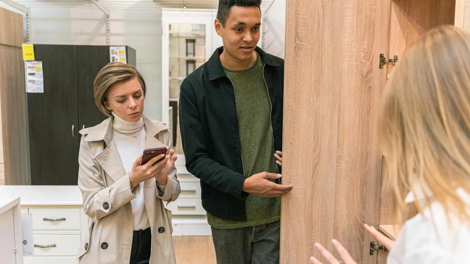 A man and woman shopping for wooden furniture in a modern retail store setting.