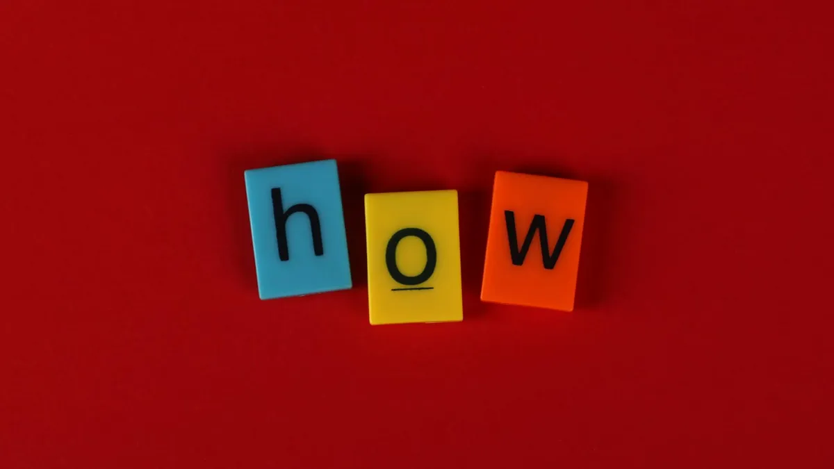 Colorful letter tiles spelling 'How' on a vibrant red background, ideal for educational content.