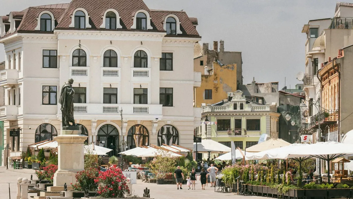 Historic square in Constanța, Romania with classic architecture and outdoor cafes.