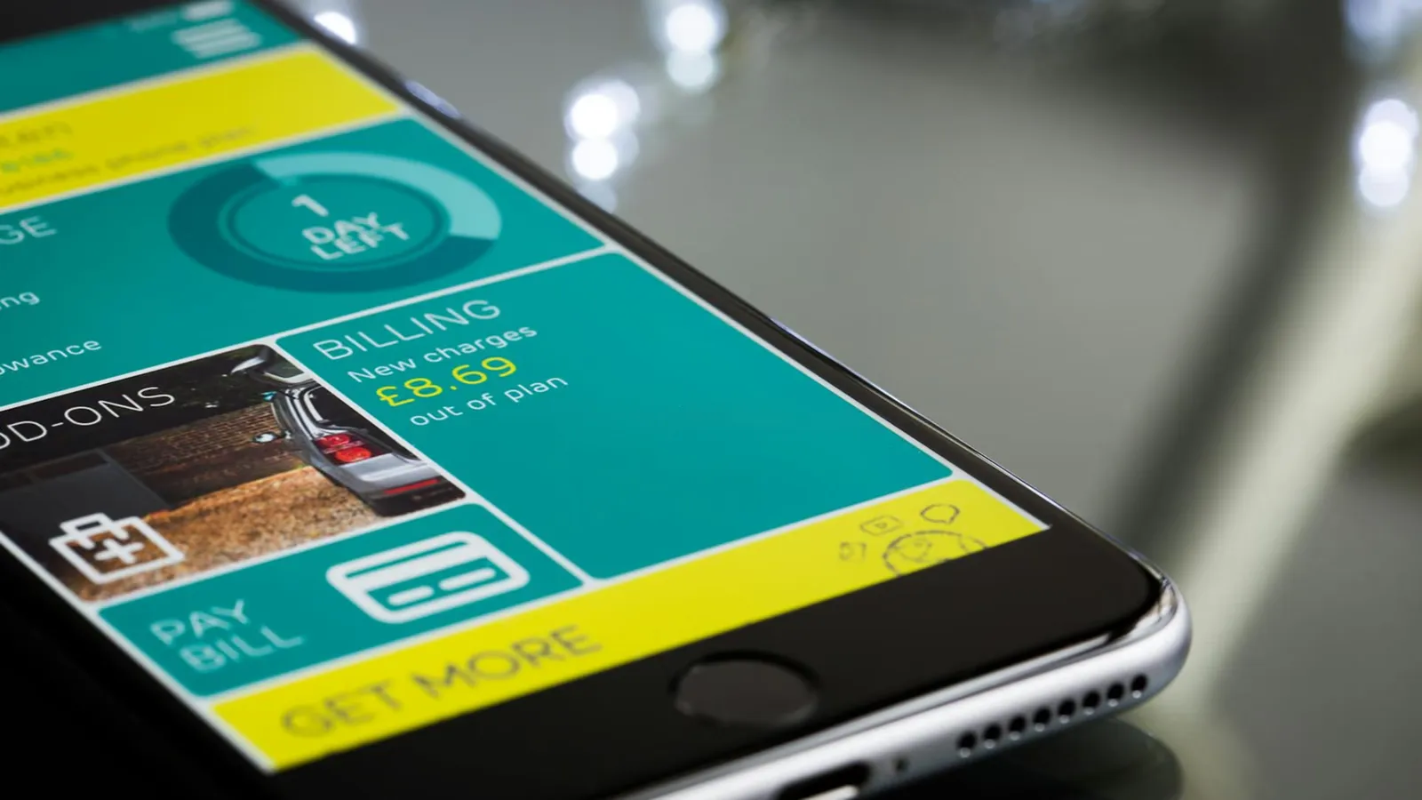 Close-up of a smartphone displaying a billing app interface on a reflective surface.