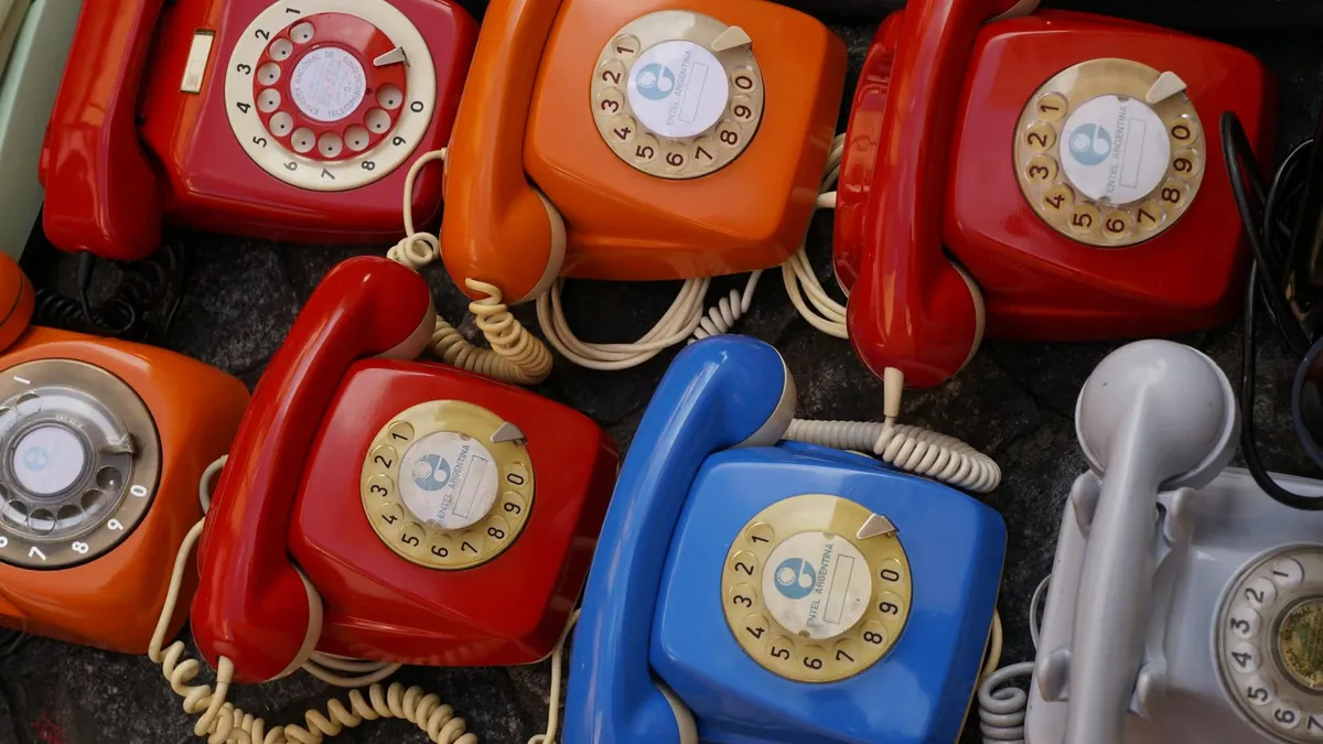 A collection of colorful vintage rotary telephones evokes nostalgic charm and retro style.
