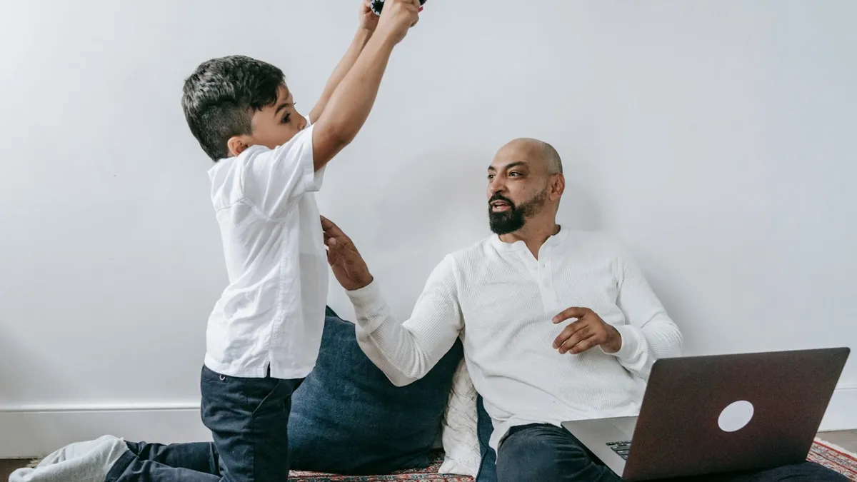 Father and son spending quality time at home, enjoying playful interaction with technology.