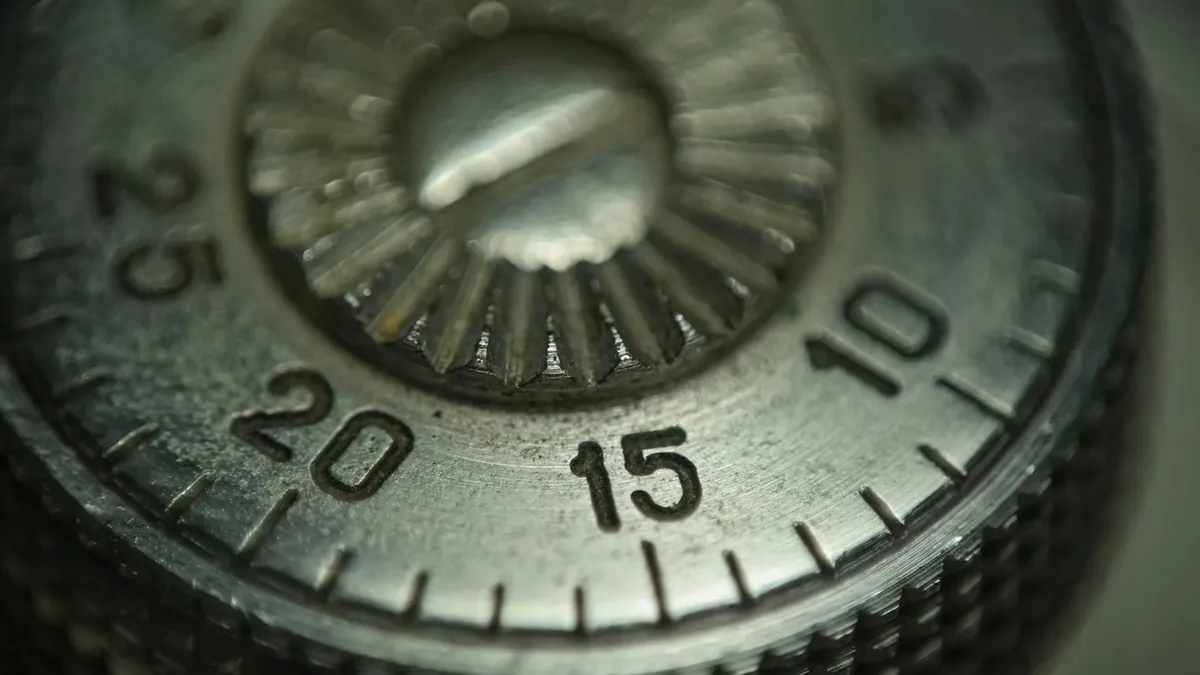 Detailed macro shot of a metallic combination lock dial showing numbers and texture.