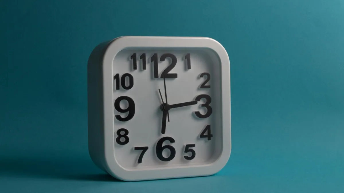 Square white wall clock displaying 10:10 against a blue backdrop, perfect for minimalistic and modern design themes.