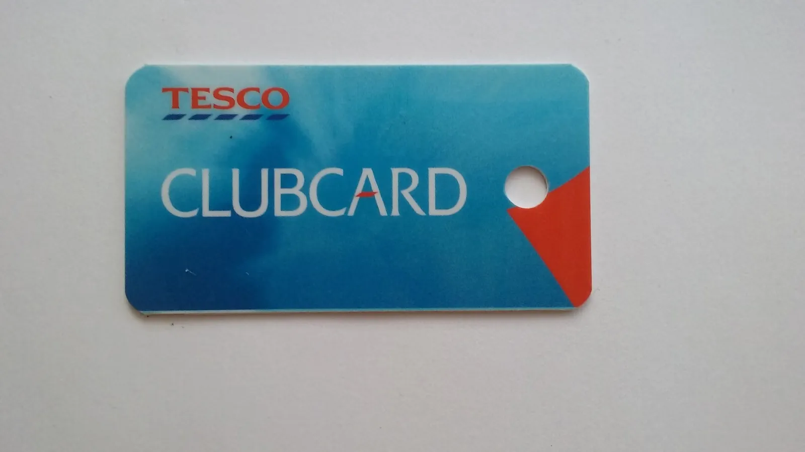 Customer holding Tesco shopping bags at a supermarket checkout