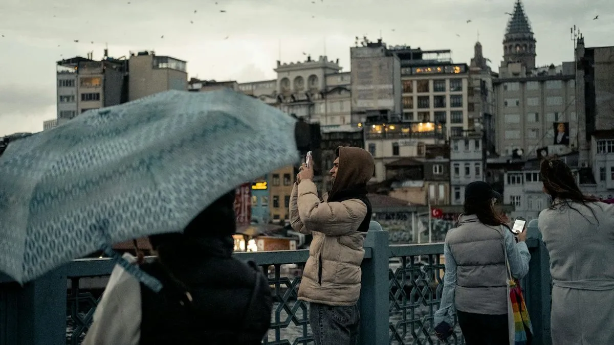 People on a bridge in Istanbul, with the Galata Tower visible in the background.