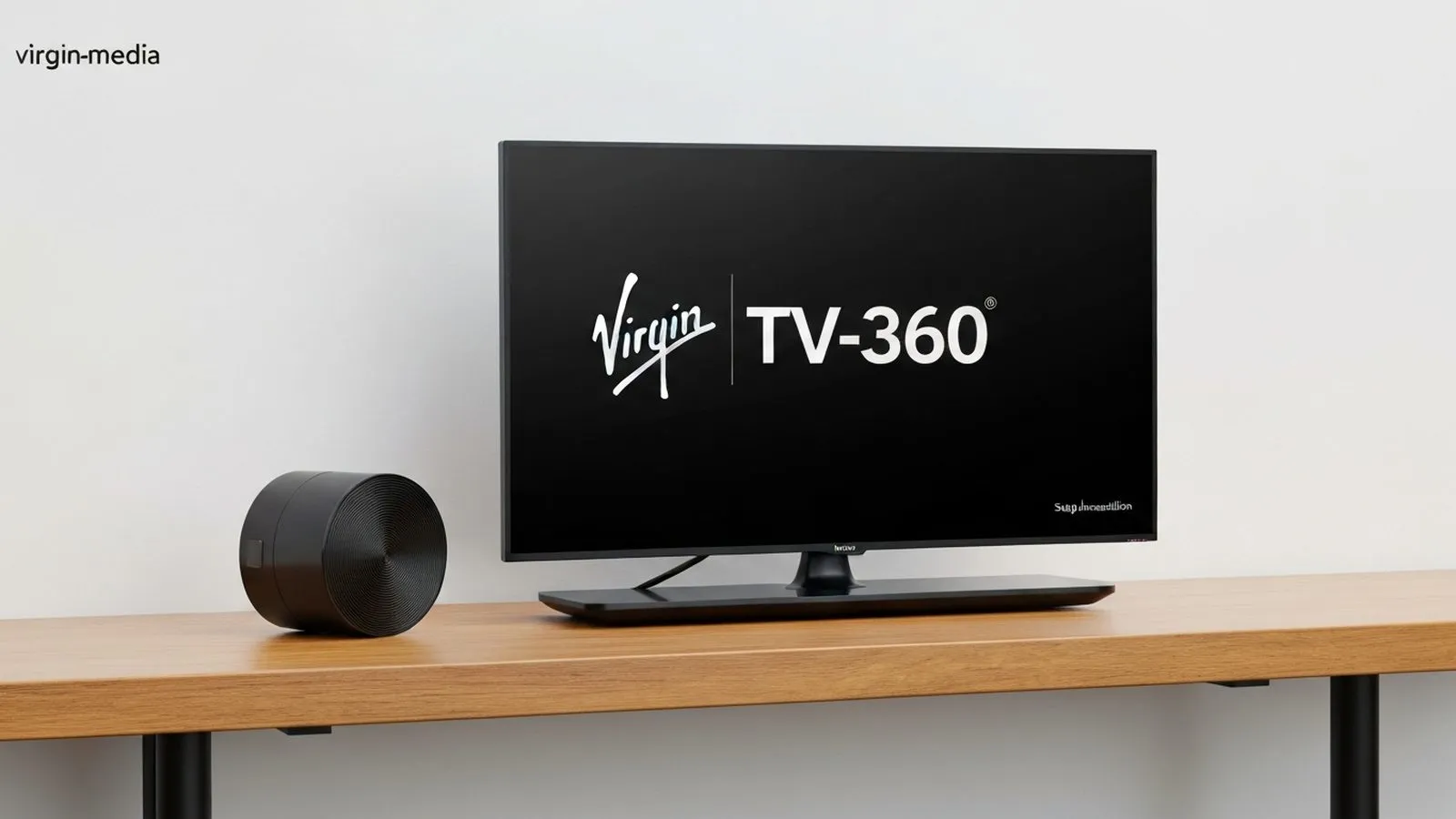 A black TV screen displaying 'Virgin TV-360' in white text, next to a black cylindrical device, on a wooden surface.