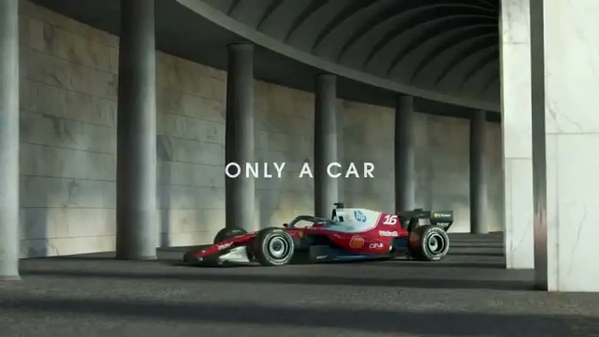 A red and white Formula 1 race car is parked in a concrete tunnel with pillars, under soft lighting.