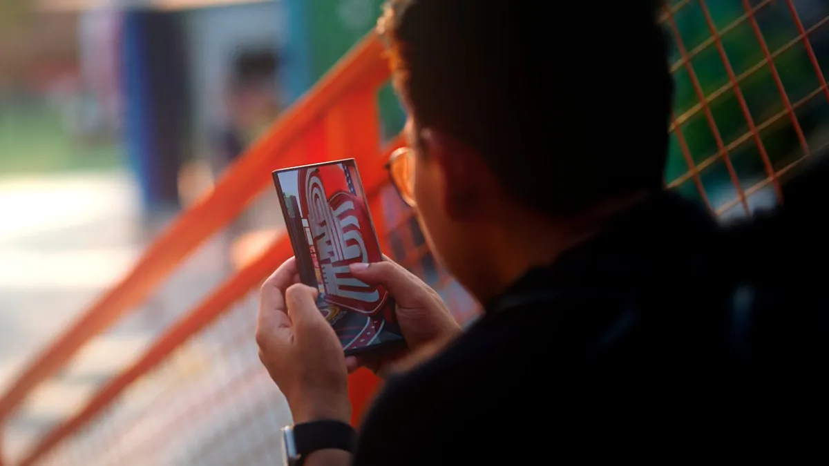 An adult man using a smartphone while sitting on colorful urban street steps.