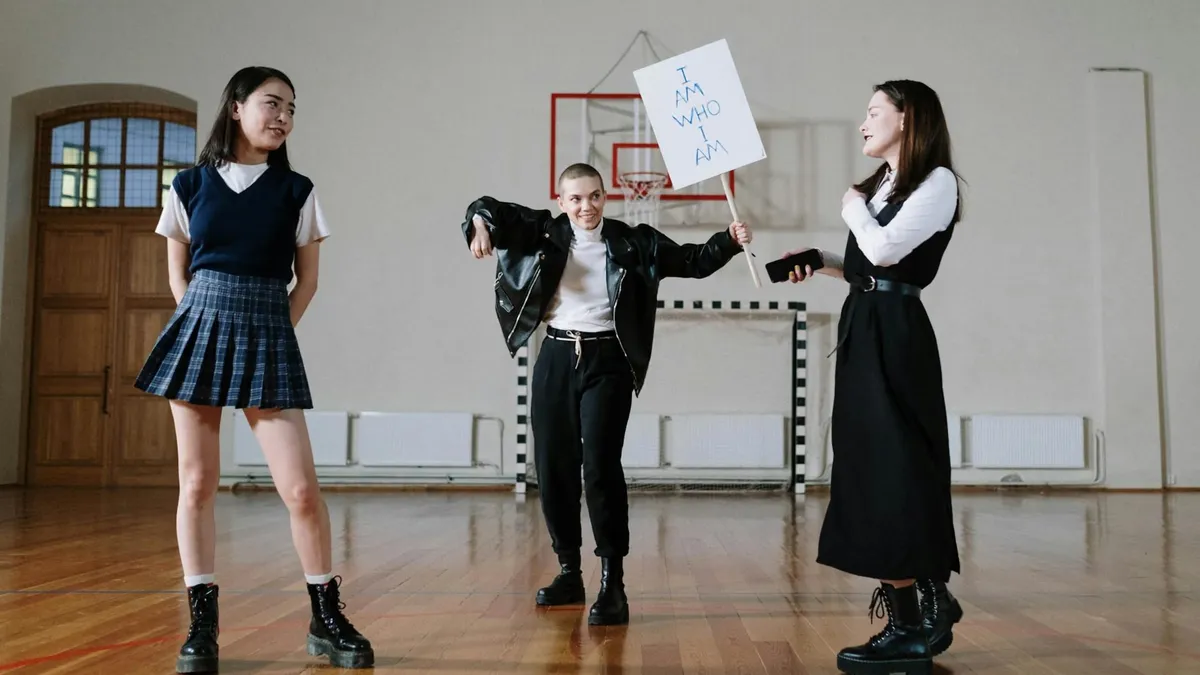 Diverse students protesting indoors holding signs with messages in a school gym.