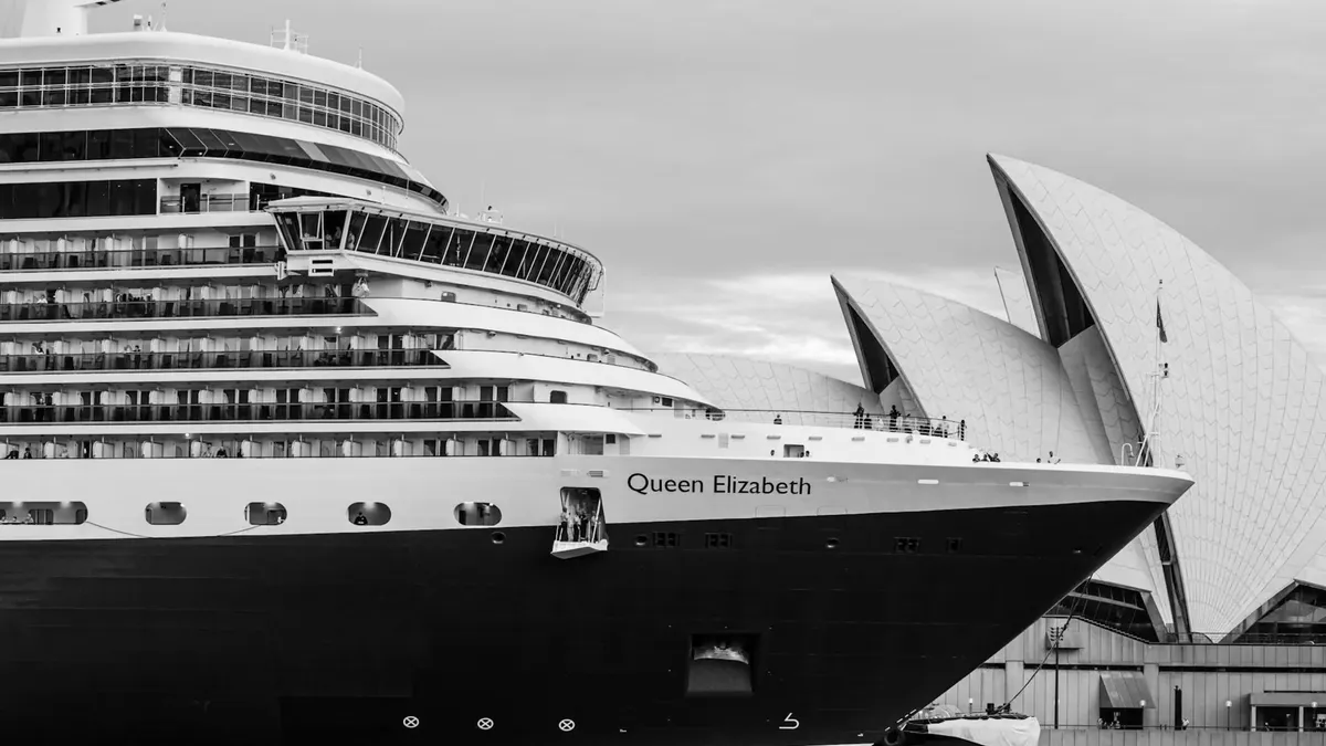 Black and white photo of Queen Elizabeth cruise ship beside the iconic Sydney Opera House.